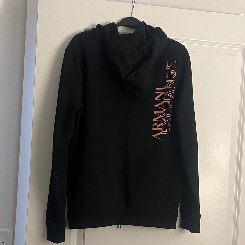 Armani Exchange unisex Black hoodie with peach colored logo on the back .